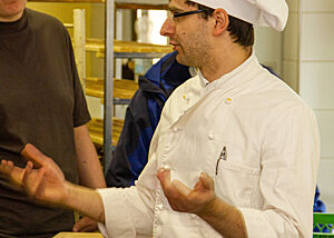 Der Meister der Bäckerei Fischer spricht mit Besuchern.