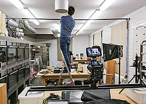 Ein Mann installiert unter der Decke die Top-Shot-Kamera