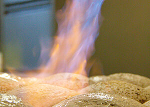 Die fertig gereiften und mit Mehlstreiche abgestrichenen Gersterbrote werden mit einem Gasbrenner geflämmt.