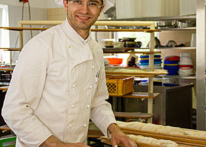 Bäckermeister Ricardo Fischer dreht Zwirbelbaguettes mit der Hand.