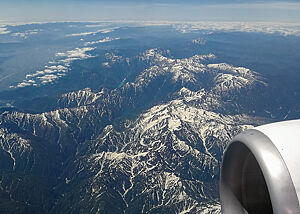 Blick aus dem Flugzeugfenster auf die schneebedeckten Berge Japans.
