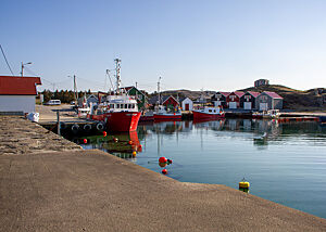 Ein kleiner Fischerhafen mit Fischerbooten und Fischerhütten.