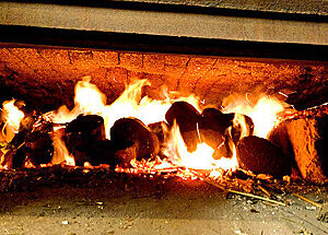 Im Steinbackofen brennen Holzscheite.