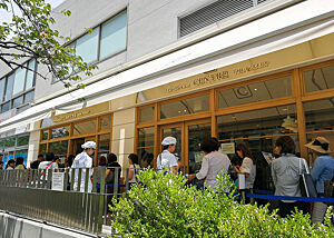 Eine Menschenschlange wartet vor einer japanischen Bäckerei.