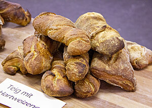Kräftig ausgebackene Hartweizen-Brote ohne Malz liegen auf einem Holztisch.