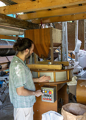 Daniele Ciabattoni erklärt uns seine Mühle. Daniele steht vor seiner Mühle aus Holz und erklärt uns die Funktion.
