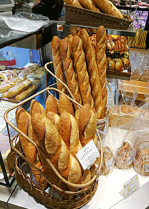 Schon wieder Baguettes. In der Auslage einer japanischen Bäckerei stehen Baguettes in Baguettekörben.