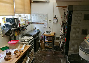 Auf engstem Raum sind Ofen, Spüle, Arbeitsfläche und Knetmaschine untergebracht.