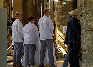 Teilnehmer warten hinter ihren Tischen auf den Einmarsch der Jury. Ein Bäcker-Team wartet im Inneren des Palais.