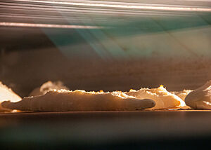 Für das Baguette ist essentiell, wann und wieviel geschwadet wird. Mehrere Baguettes backen im Ofen hinter einer Glasscheibe.