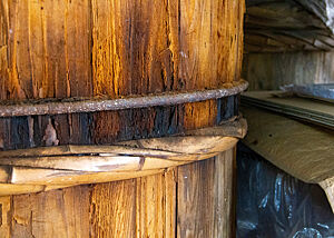 Ein altes Holzfass mit einem Stahlring und einem Ring aus Bambus, die das Fass zusammenhalten.