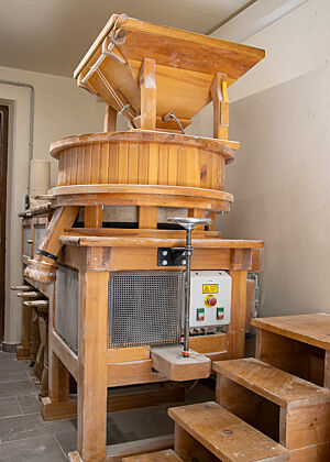 Die Osttiroler Steinmühle der Biohofbäckerei Folie. Die Steinmühle ist aus hellem Holz gebaut.