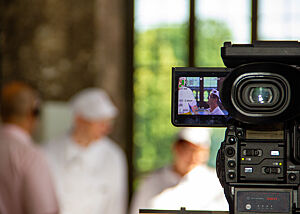 Eine Kamera filmt ein Bäcker-Team.