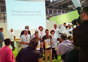 Gruppenbild bei der Siegerehrung der Wild Bakers (in braun). Die stolzen Sieger posieren mit ihren Medaillen und Urkunden bei der Siegerehrung für ein Gruppenbild.