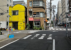 Eine leere Straße, gesäumt von unterschiedlichsten Häusern in Tokio.