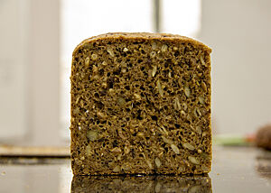 Körner- und Saatenbrot aus unserem Kurs. Ein Kastenbrot zeigt im Anschnitt die braune Krume mit Körnern und Saaten.