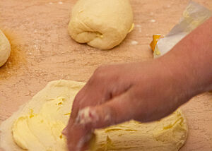 Der portionierte Bogaçe-Teig wird von Hand mit Butter bestrichen.