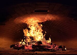Es wird ordentlich eingeheizt Im Ofen brennt ein großes Feuer. Es hat sich schon einiges an Glut gebildet.