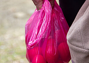 In einer roten Plastiktüte werden rote Ostereier davongetragen.