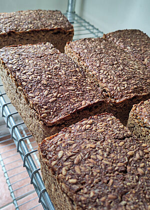 Fertig gebackene Schwarzbrote mit Sonnenblumenkernen. Die Schwarzbrote sollten etwas kräftiger als bislang schmecken. Deshalb habe ich die Sauerteigführung angepasst und Details in der Rezeptur verändert.
