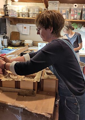 Teiglinge in die Rahmen setzen Sibylle setzt die runden Teiglinge in die mit Packpapier ausgekleideten Backrahmen.