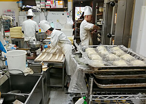 Blick in die Mini-Backstube der Bäckerei Zopf in der täglich 300 verschiedene Backwaren entstehen. Drei Bäcker arbeiten in der kleinen Backstube der Bäckerei Zopf.