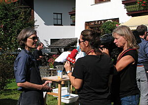 Eine Kamerafrau filmt Christina Weiß im Gespräch mit einer Reporterin.