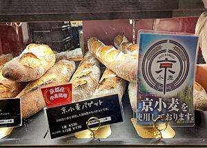 Ein Werbeschild in der Auslage einer Bäckerei verspricht Baguettes aus einheimischem Weizen.