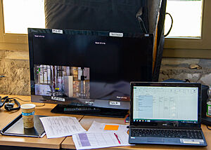 Die Regie hat die Fäden über die realistische oder verzerrte Darstellung der Bäcker in der Hand. Auf einem Schreibtisch stehen Monitor, Laptop und einige Ausdrucke.