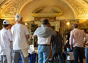 Mehrere Bäckerteams warten in einem Raum des Palais.