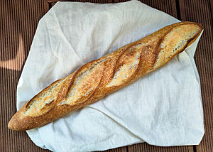 Das sehr empfehlenswerte Baguette aus der Parnell Street Bakery. Goldbraun gebackenes Baguette mit vier Einschnitten und Süßbläschen auf der Kruste.