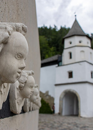 Eingangsbereich von Marienberg. Geflügelte Puttenköpfe grüßen den Besucher auf dem Weg zum Eingang ins Kloster.