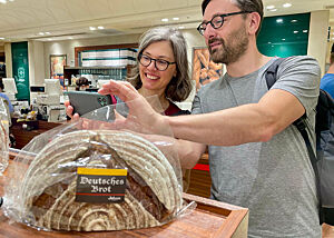 Christina Weiß und Lutz Geißler fotografieren eine Packung mit der Aufschrift "Deutsches Brot".