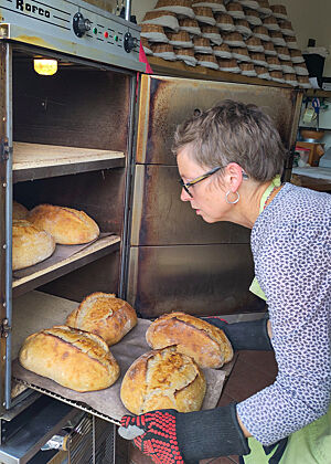 Nach der halben Backzeit werden die Brote in andere Ebenen verschoben, damit sie gleichmäßig backen. Angela tauscht die Brote im Ofen aus.