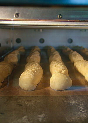 Im Ofen werden hinter einer Glasscheibe Dinkelbaguettes gebacken.