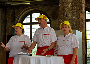 Bäcker Süpke und sein Team stehen an einem Tisch mit weißer Decke.