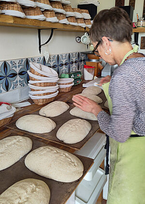 Angela Nöthlings schneidet die Bloomer-Teiglinge vor dem Backen ein. Die Teiglinge wurden auf Backfolien gestürzt und werden anschließend mit der Rasierklinge eingeschnitten.
