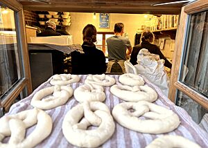 Die fertig angehauteten Brezeln werden durch das geöffnete Fenster ins Backhaus gereicht um dort gelaugt zu werden.