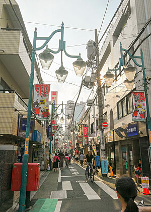 Eine belebte, schmale Straße in Tokio.  