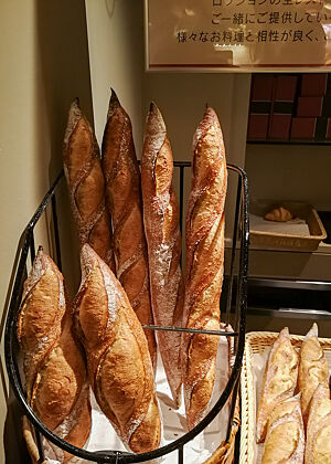 Baguettes überall ... Mehrere Baguettes stehen in Baguetteständern in der Auslage einer Bäckerei.