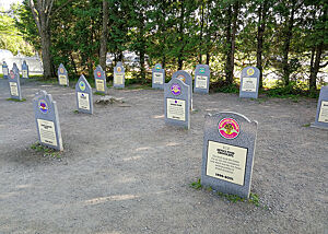Der Eissorten-Friedhof von Ben & Jerrys. Auf einer ebenen Fläche stehen grabsteinähnlichen Platten, auf denen Eissorten von Ben & Jerrys verewigt sind.