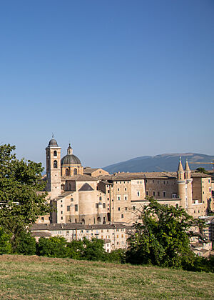 Aus hellgelben Steinen erbaut, erhebt sich Urbino als dichte Ansammlung trutziger, mittelalterlich anmutender Gebäude.
