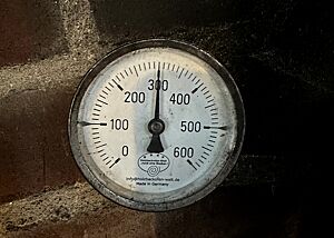 Ein analoges Ofenthermometer zeigt die Temperatur im Lehmbackofen an. 