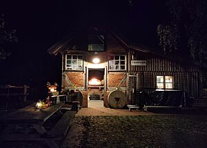 Der Tag neigt sich dem Ende Das gemütlich erleuchtete Backhaus im Dunkeln.