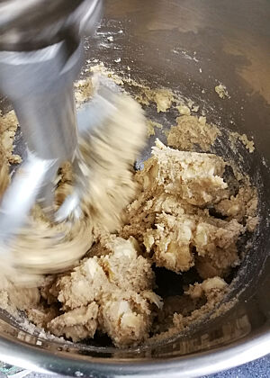 Stollenteig. In einer Schüssel wird Stollenteig maschinell geknetet.