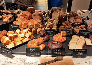 Bagels, Toast, Shokupan, Bananenbrot und Muffins auf einem Tisch im Hotel.