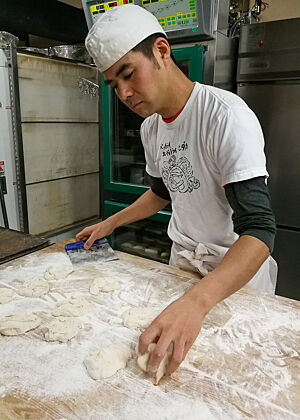 Bäcker Hidaka in Iwami Ginzan, der gemeinsam mit seiner Frau wohl die einzige Bäckerei und Konditorei Japans mit zwei deutschen Meisterbriefen betreibt. Bäcker Hidaka portioniert Teiglinge.