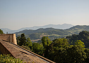 Über den Festungswall aus Backstein sieht man bis zum Horizont grüne Hügel mit Wäldern und Weinbergen.
