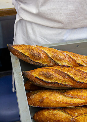 Baguettes mit 0,1 % Frischhefe Tiefbraune Baguettes liegen in einer Kiste.