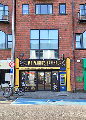 My Patrik's Bakery in Killarney ist benannt nach dem Sohn von Bäcker Seky. Ein Backsteingebäude mit braun-gelbem Eingangsbereich zur Bäckerei.